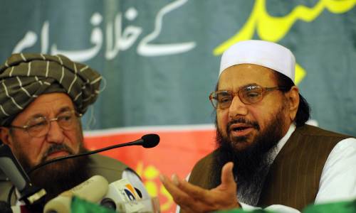 Hafiz Saeed (right), the founder of Lashkar-e-Taiba, talks to media representatives as Maulana Samiul Haq (left), chief of the Defence Council of Pakistan and dubbed father of the Taliban, looks on during a news conference in Rawalpindi on Wednesday. (AFP-Yonhap News)