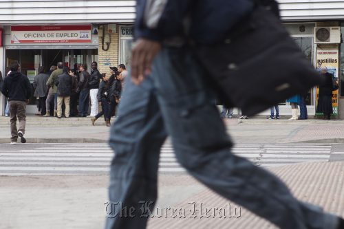 Job-seekers wait outside a job center before opening in Madrid. (Bloomberg)