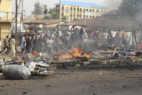 People gather at the site of a bomb explosion at a road in Kaduna, Nigeria on Sunday. (AP-Yonhap News)