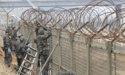 Soldiers dismantle the fencing along the southern bank of the Han River in Gimpo on Monday. (Yonhap News)