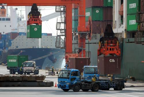 Cranes hoist containers on board a ship at a pier in Tokyo. (AFP-Yonhap News)