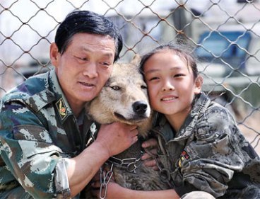 Zhu Yongsheng and his daughter Zhu Lin cuddle a wolf at the family`s animal training base in Urumqi, the Xinjiang Uygur autonomous region, on Saturday. (ANN/China Daily)
