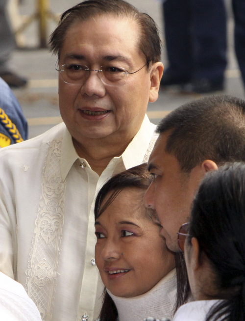 Former Philippine President Gloria Macapagal Arroyo (center), together with her husband Jose Miguel Arroyo (left) and son (right), arrives at a special anti -graft court called Sandiganbayan for her arraignment Wednesday. (AP-Yonhap News)