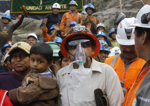 Miner Jacinto Pariona (center right) stands with his family after he was the first miner to be rescued from the Cabeza de Negro gold-and-copper mine in Yauca del Rosario, Peru, Wednesday. (AP-Yonhap News)