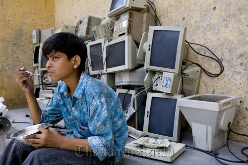 Discarded computer monitors are stacked in a recycling garage. (Bloomberg)