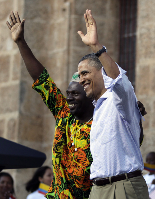 President Barack Obama (right) waves with Sebastian Salgado, of the Afro-Colombian San Basilio de Palenque community, during a land titling event at the San Pedro Claver square in Cartagena, Colombia on Sunday. (AP-Yonhap News)