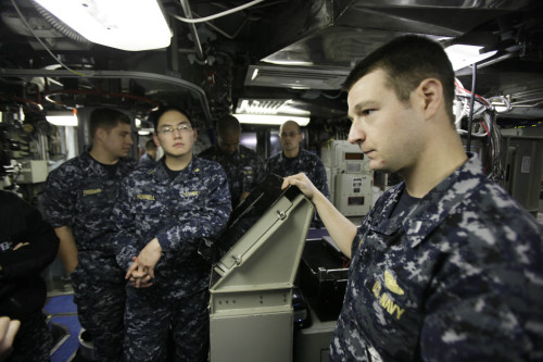 In this Monday, March 12, 2012 photo, Lt. Steven Weiner, of Stony Brook, N.Y., right, stands with other crew members in the control room on the USS Connecticut, a Sea Wolf-class nuclear submarine, during a port call at a U.S. naval base at Yokosuka, south of Tokyo, Japan. (AP)