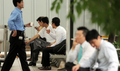 Office workers smoke outside their company buildings in Yeouido, central Seoul. (Ahn Hoon/The Korea Herald)