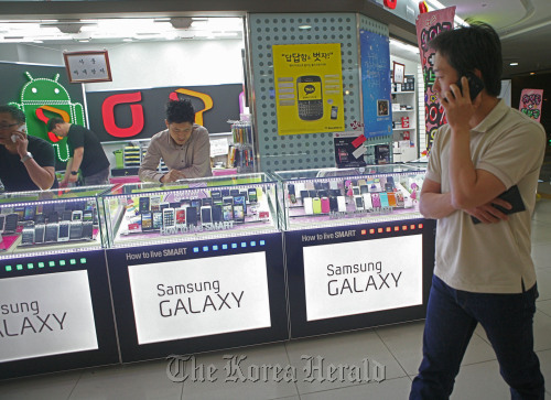 A man walks past a mobile phone store in Seoul. (Bloomberg)