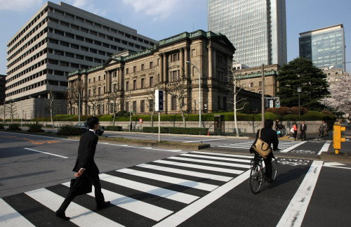 Pedestrians walk past the Bank of Japan headquarters in Tokyo. (Bloomberg)