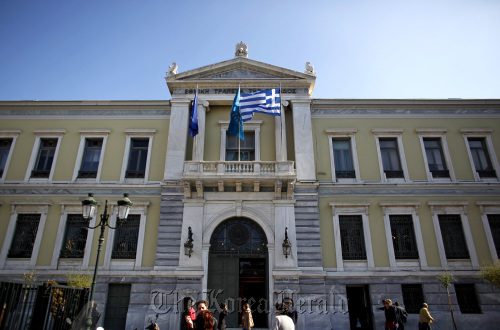 Pedestrians pass the headquarters of the National Bank of Greece SA in Athens. (Bloomberg)