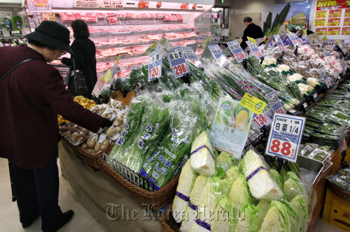 A shopper looks at vegetables in a supermarket in Tokyo. (Bloomberg)