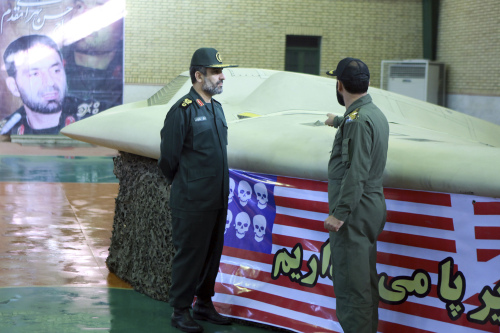 This file photo released on Dec. 8, by the Iranian Revolutionary Guards, claims to show the chief of the aerospace division of Iran’s Revolutionary Guards, Gen. Amir Ali Hajizadeh (left), listening to an unidentified colonel as he points to U.S. RQ-170 Sentinel drone which Tehran says its forces downed earlier this week. (AP-Yonhap News)