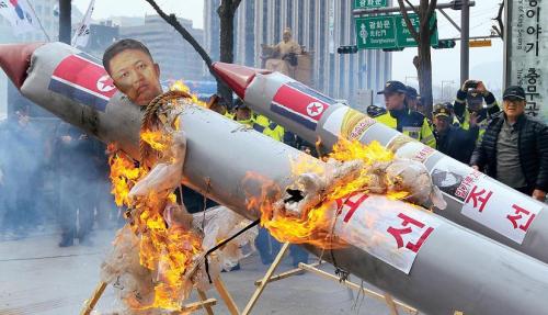 Protestors burn a mock missile in Seoul to oppose Pyongyang’s recent long range-missile test. (Yonhap News)