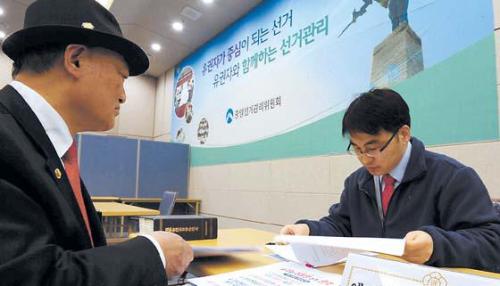 An applicant submits his documents to register his candidacy for the December presidential election at the National Election Commission’s building in Gwacheon, Gyeonggi Province, on Monday as the agency began receiving preliminary candidate registrations. (Yonhap News)