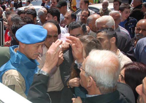 A U.N. observer (left) speaks with Syrian citizens during their visit to the pro-Syrian regime neighborhoods, in Homs province on Monday. (AP-Yonhap News)