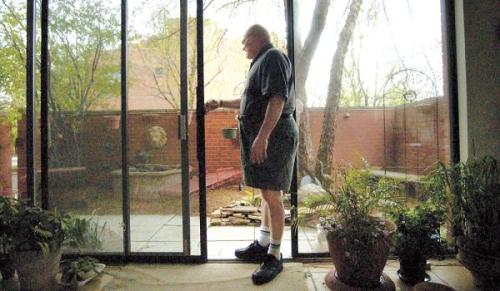 Les Dennis, who has been diagnosed with early-stage Alzheimer’s disease, checks on the plants outside his Printer’s Row apartment he shares with wife, Barbara in Chicago. (MCT)