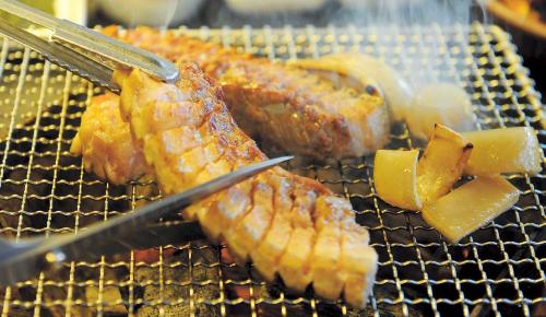Ggeomeokchon’s Jeju black ogyeopsal (five-layered pork belly) is grilled in thick slabs over hardwood charcoal, along with complementary pork rind, for a flame-kisse, steak-like experience (Lee Sang-sub/The Korea Herald)