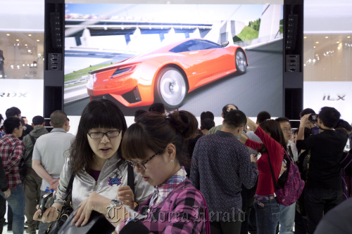 People attend the auto show in Beijing on Friday. (Bloomberg)