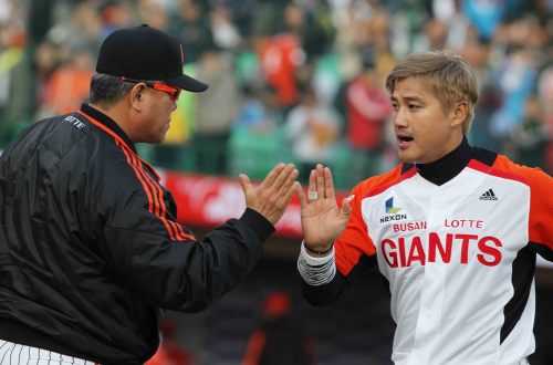 Lotte manager Yang Seung-ho (left) high-fives slugger Hong Sung-heon. (Yonhap News)