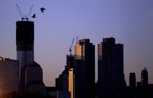 Viewed from Jersey City, N.J., two birds fly by as the sun rises over buildingsin New York, including One World Trade Center, tallest building at left, Monday, April 30, 2012. (AP)