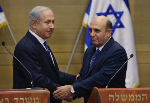 Israel’s Prime Minister Benjamin Netanyahu (left) and Kadima party leader Shaul Mofaz shake hands before holding a joint press conference announcing the new coalition government in Jerusalem on Tuesday. (AP-Yonhap News)