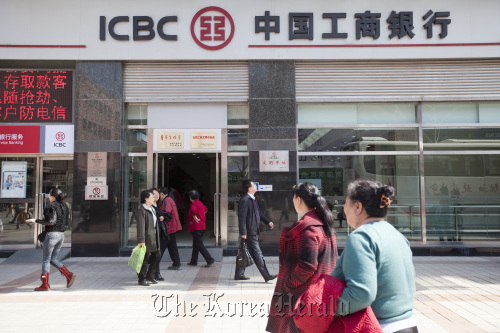 Pedestrians walk past a branch of the Industrial and Commercial Bank of China Ltd. in Beijing. (Bloomberg)