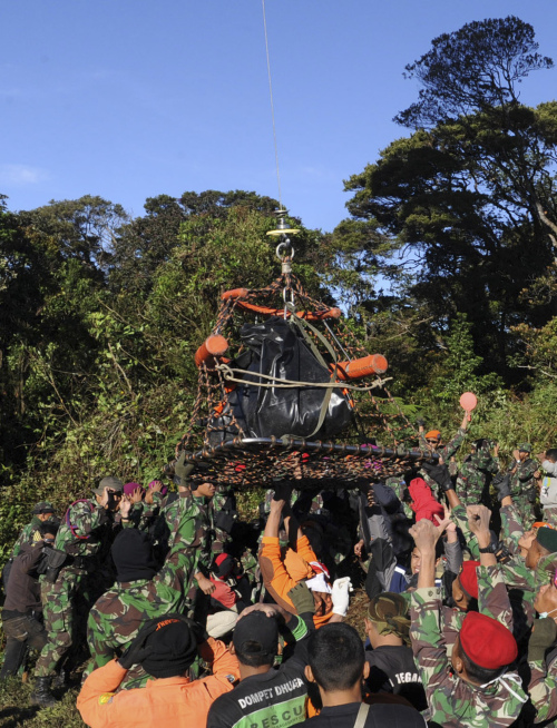 Indonesian soldiers and rescuers load a victim of Wednesday’s plane crash onto a helicopter at the site in Mount Salak, Bogor, West Java on Saturday. (AP-Yonhap News)