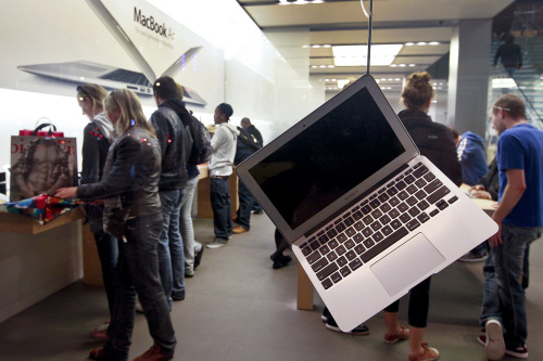 Shoppers look at Apple Inc. products as a MacBook Air laptop computer sits on display at an Apple store in San Francisco, California. (Bloomberg)