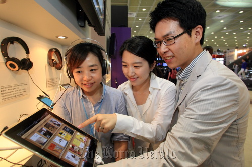 People take a look at digital content using KT’s Olleh ebook service at the World IT Show 2012 in southern Seoul on Wednesday.