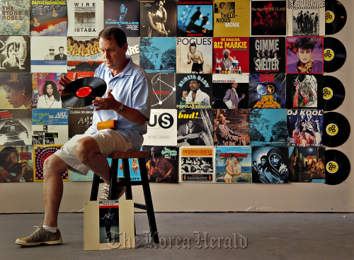 Sean Kayes of Radio-Active Records inspects a disc inside the record store in Fort Lauderdale, Florida. (Miami Herald/MCT)