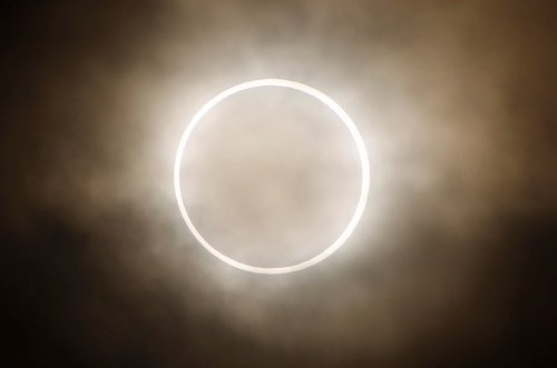 The moon slides across the sun, showing a blazing halo of light, during an annular eclipse at a waterfront park in Yokohama, near Tokyo, Monday. (AP-Yonhap News)