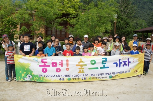 Volunteer workers from Cardif in Korea and children from the Dong-myung Child Welfare Center pose before attending a forest exploration program on Saturday. (Cardif in Korea)