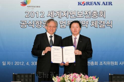 Woo Kee-hong (right), senior vice president of Korean Air’s passenger business, poses with Kim Chong-chun, secretary general of the Korean Organizing Committee for the 2012 IUCN World Conservation Congress, after they signed a sponsorship agreement at the KOC office in Seoul on April 3. (Korean Organizing Committee for the 2012 WCC)