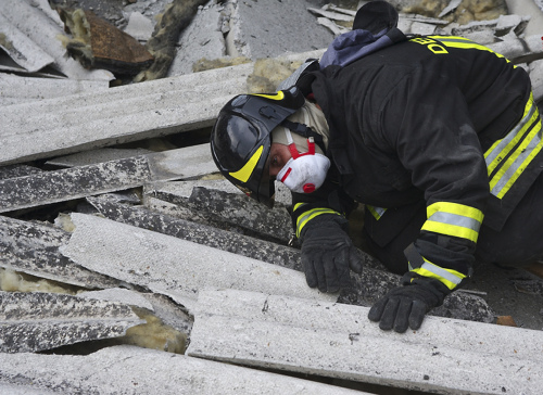 A firefighter works amid debris in Sant’ Agostino, northern Italy, Sunday. (AP-Yonhap News)