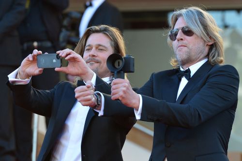 U.S. actor Brad Pitt (left) takes pictures with his smartphone as New Zealand’s director Andrew Dominik plays with a small camera before the screening of “Killing Them Softly” at the 65th Cannes Film Festival on Tuesday. (AFP-Yonhap News)