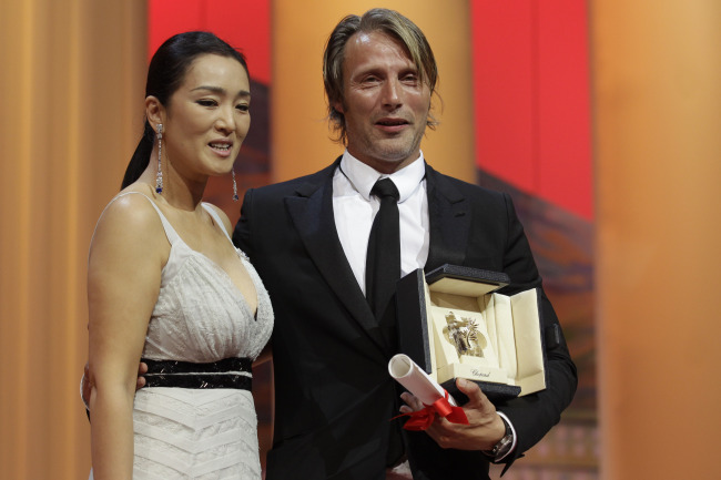 Actor Mads Mikkelsen (right) poses on stage with actress Gong Li as he is presented with the Best Actor award for The Hunt, at the 65th international film festival in Cannes on Sunday. (AP-Yonhap News)