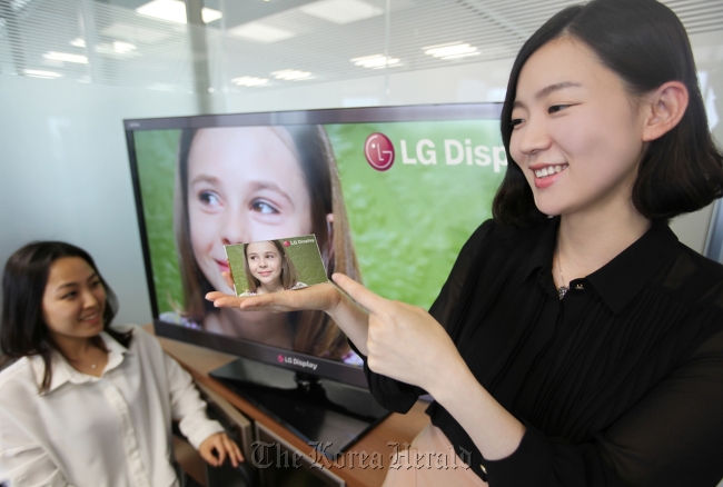 A model points to LG Display’s five-inch HD panel for smartphones in her hand. (LG Display)