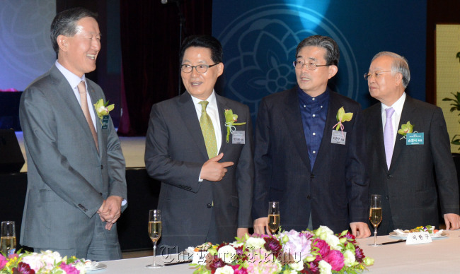 Park Jie-won (second from left), the floor leader of the main opposition United Democratic Party, gestures to Huh Chang-soo (left), chairman of the Federation of Korean Industries and Sohn Kyung-shik (right), chairman of the Korea Chamber of Commerce and Industry during an event to celebrate the inauguration of the 19th National Assembly in Yeouido, Seoul, Wednesday. (Ahn Hoon/The Korea Herald)