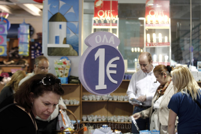 Customers browse discounted goods for sale at a “one euro store” in Athens. (Bloomberg)