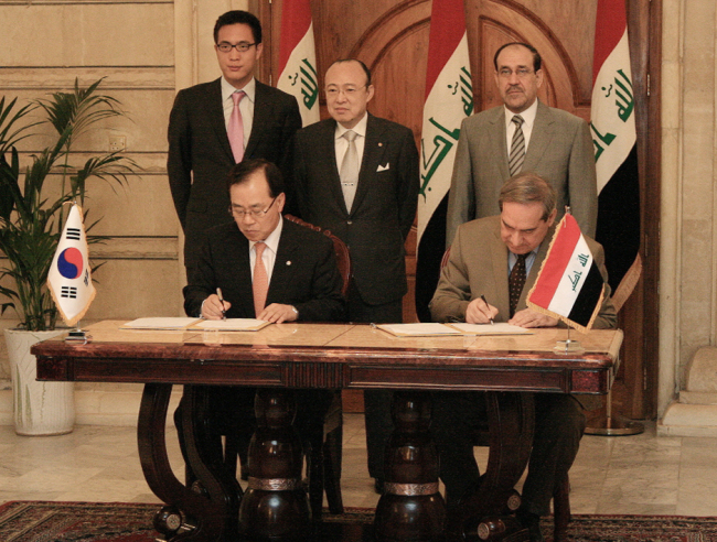 Hanwha Group chairman Kim Seung-youn (standing at the center) poses during an event in which the conglomerate signed a contract to build 100,000 houses in Bismayah, Iraq, at the Iraqi Premier’s Office in Baghdad on Wednesday. (Hanwha Group)