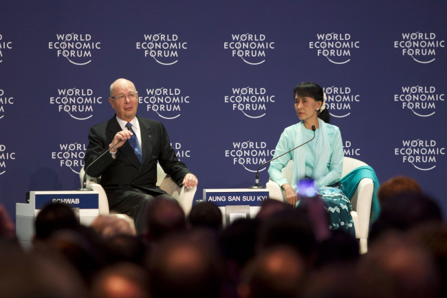 Aung San Suu Kyi, Myanmar’s opposition leader (right) listens while Klaus Schwab, founder and chairman of the World Economic Forum, speaks at the World Economic Forum on East Asia 2012 in Bangkok on Friday. (Bloomberg)