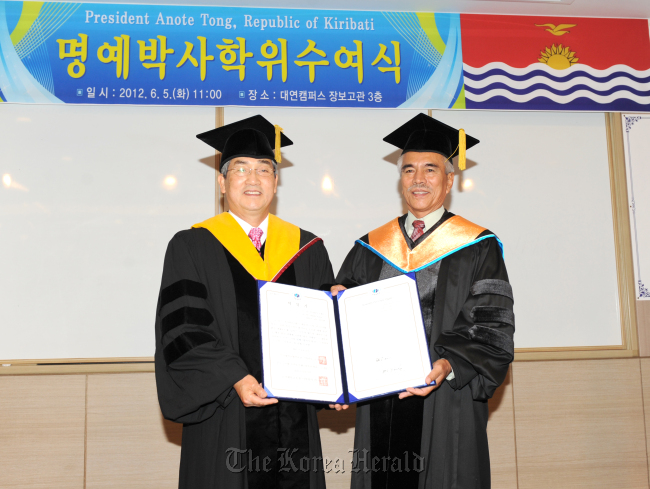 Kiribati President Anote Tong (right) poses with Pukyong National University president Park Maeng-eon after receiving an honorary doctorate from the school in Busan on Tuesday.