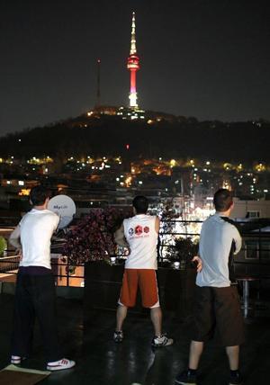 Kim stretches after a night session with his boxing students under the Namsam Tower. (Yonhap News)