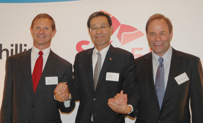 SK E&S CEO Moon Duk-kyu (center) poses with ConocoPhillips Australia president Todd Creeger (left) and Santos CEO David Knox after signing a contract in Kuala Lumpur, on Thursday. (SK Group)