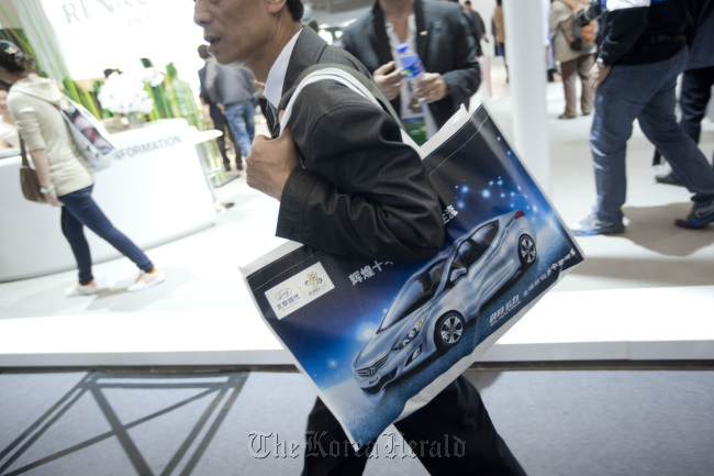 A man walks with a bag depicting a Hyundai Motor Co. Elantra automobile at the auto show in Beijing, China, in April 2012. (Bloomberg)