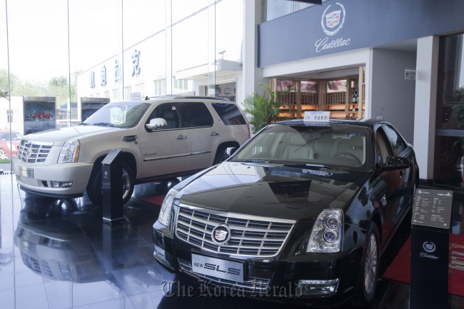 A General Motors Co. Cadillac Escalade Hybrid, left, and an SLS automobile are displayed in a dealership in Beijing. (Bloomberg)