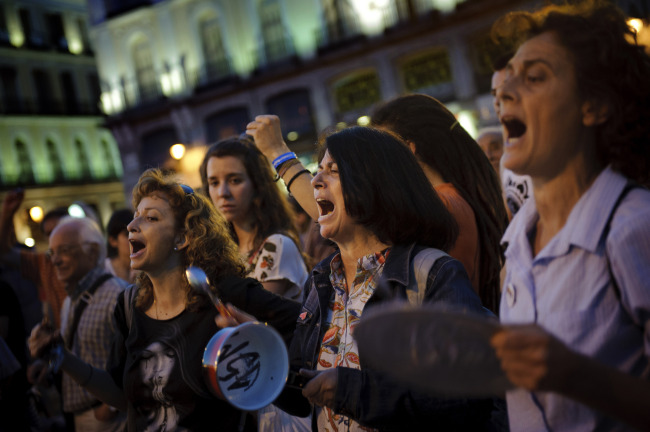 Demonstrators bang pots during a protest against the financial crisis and the latest government Economic measures in Sol square, Madrid, Sunday. (AP-Yonhap News)