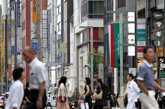 Pedestrians walk past commercial buildings in the Ginza district of Tokyo. (Bloomberg)