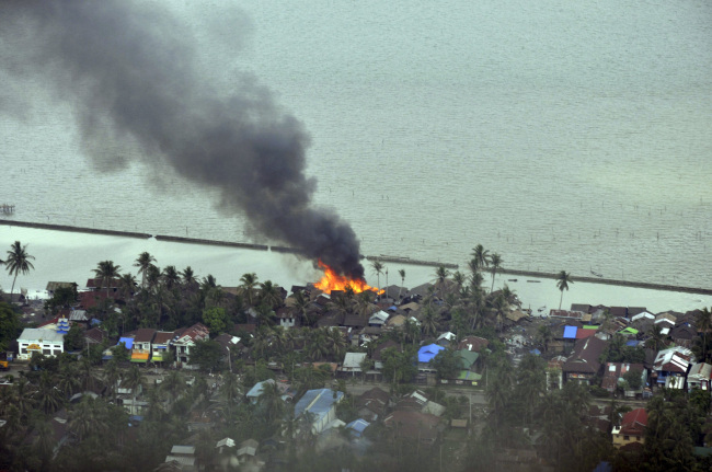 Smokes and flames are billowing from burning buildings at a village in Sittwe, capital of Rakhine state in western Myanmar, where sectarian violence are ongoing Monday. (AP-Yonhap News)